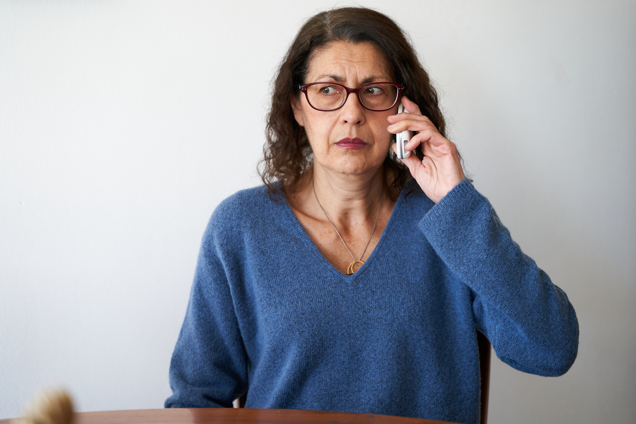 AI calling you, phone scams older woman on phone suspicious