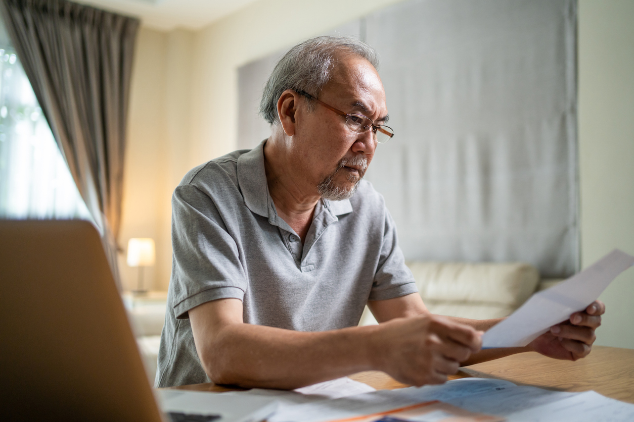 DME Fraud, Depressed Asian Senior male feeling worried about financial problem.