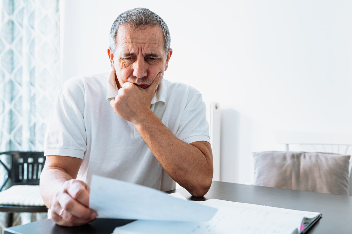social security administration, scam, older man looking concerned at an open letter